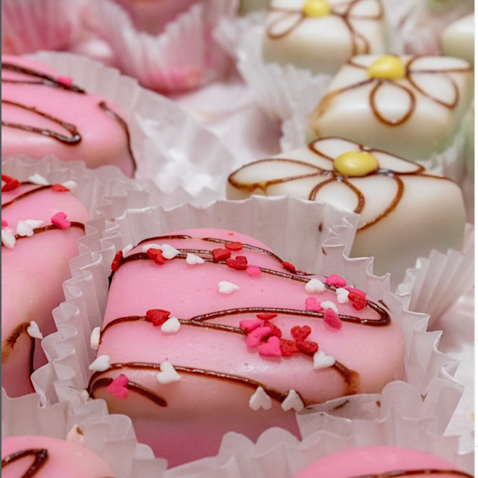 Petit Fours with pink and white fondant icing, heart shapes, and flower designs.
