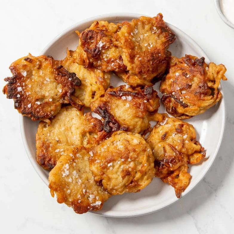 10 fried potato latkes dusted with salt on a white plate
