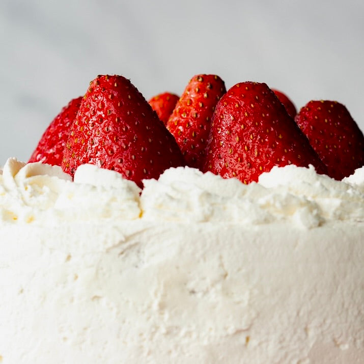 Top of William Greenberg Whole strawberry cream cake on a red cake plate