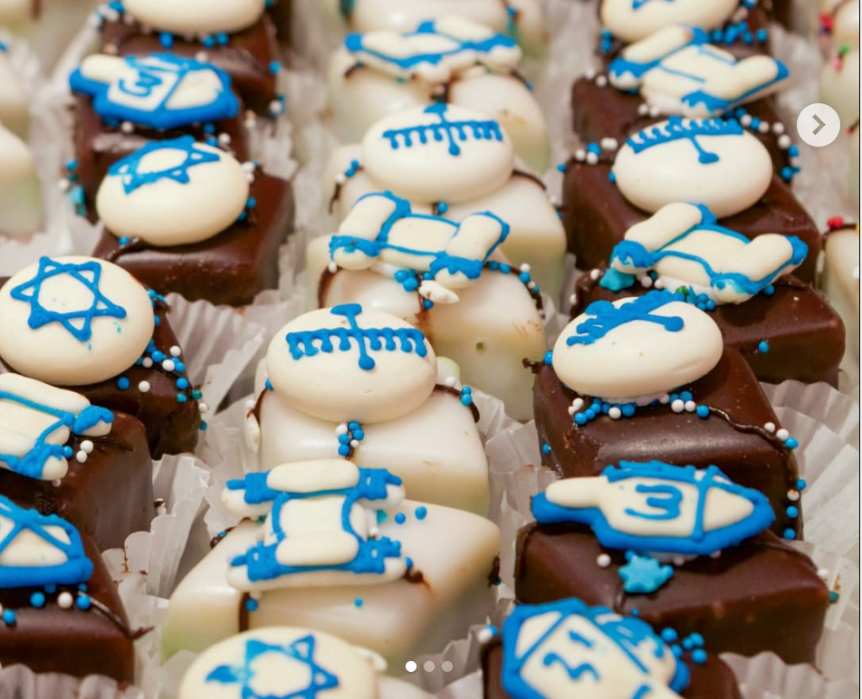 Chocolate and white mini cakes decorated with blue Hanukkah-themed designs.