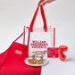 William Greenberg Desserts kids baking kit featuring an apron, recipes, 4 cupcakes, measuring spoons, a whisk and a mixing spoon.