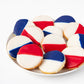 Plate of William Greenberg Desserts Black & White cookies with red, white, and blue icing on a white plate