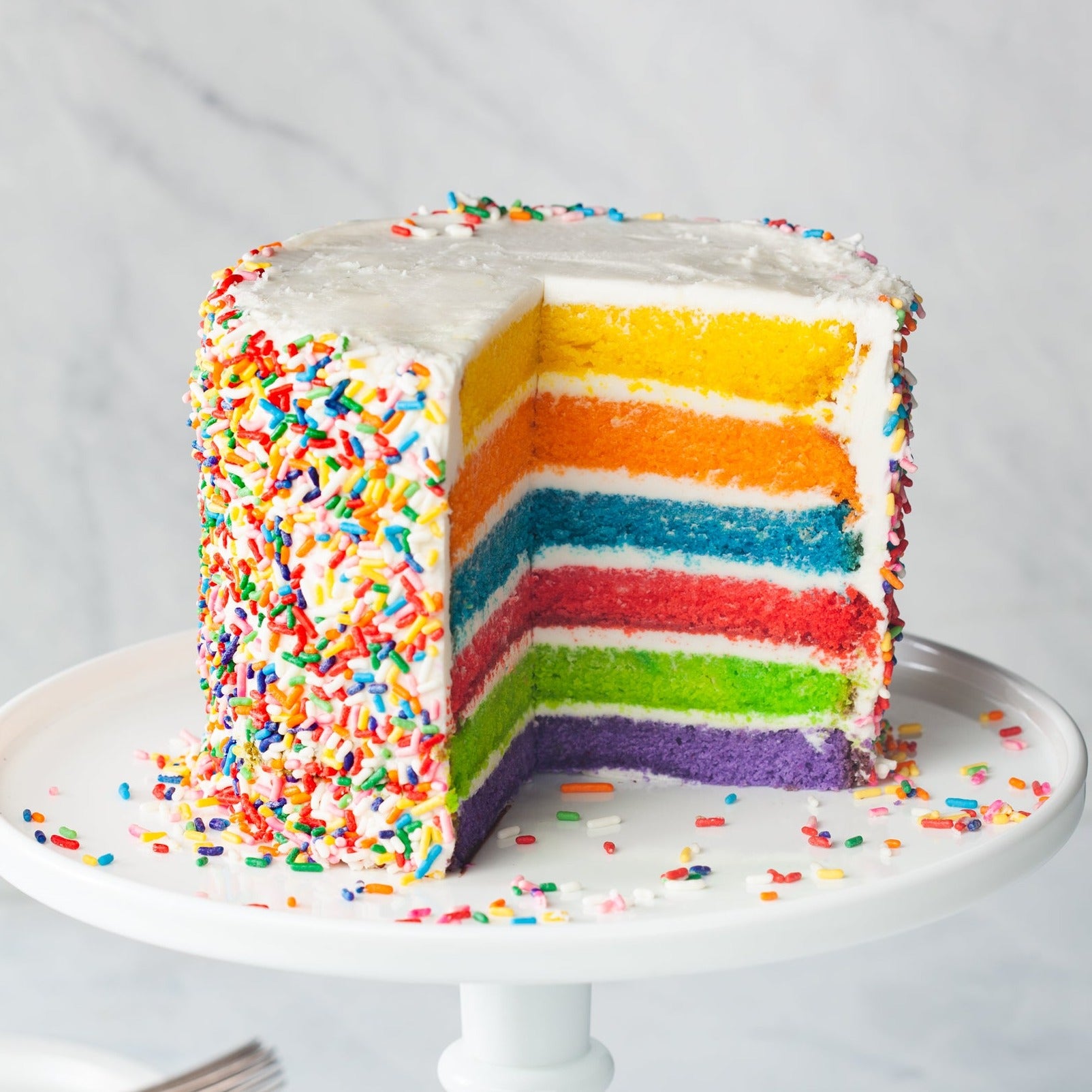 Rainbow cake with buttercream icing and sprinkles