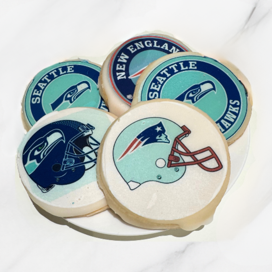 Cookies with Seattle Seahawks and New England Patriots logos on a white plate.