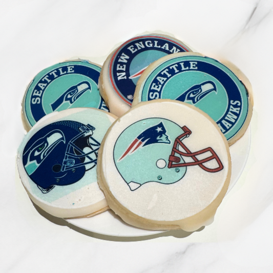 Cookies with Seattle Seahawks and New England Patriots logos on a white plate.