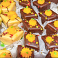 Assorted petit fours with pumpkins and Thanksgiving designs from William Greenberg Desserts on a white paper background