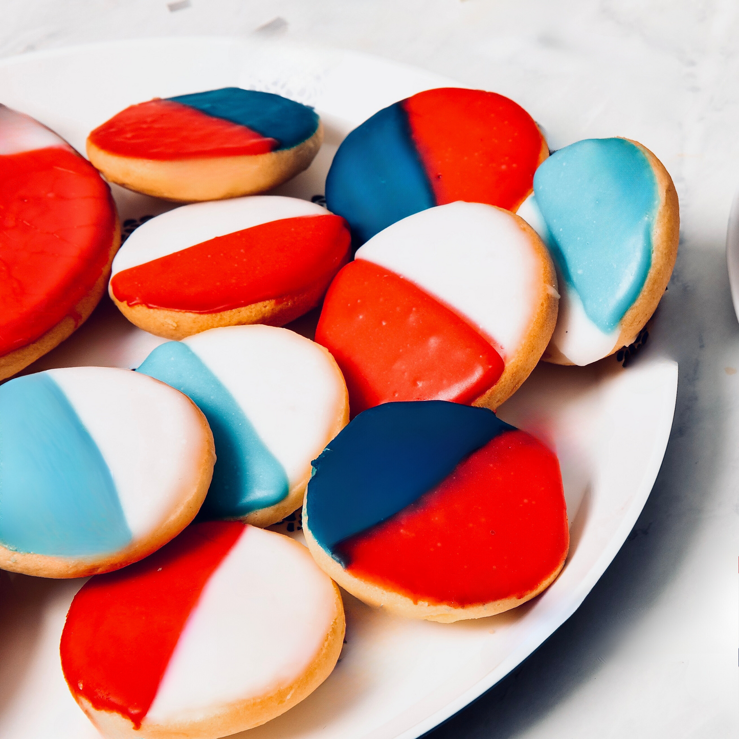 Red, white and blue cookies on a white plate.