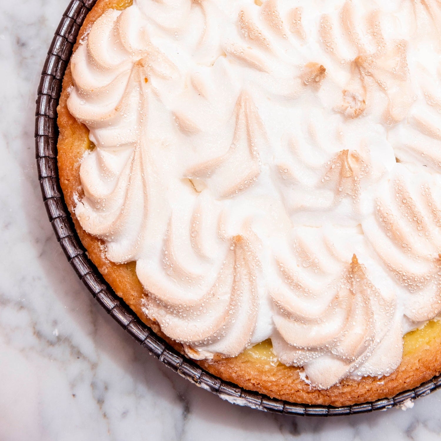 lemon meriangue Pie with meringue topping on a marble surface