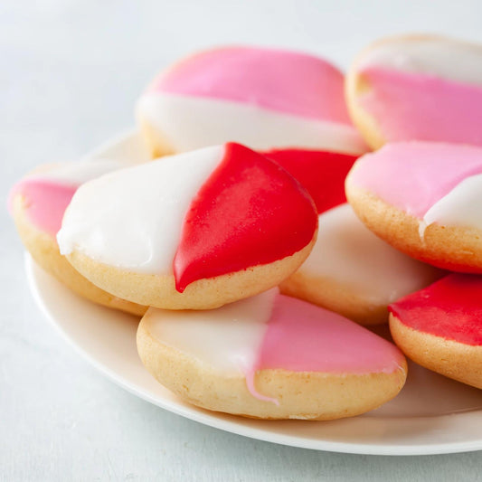 A white plate with pink and red and white cookies