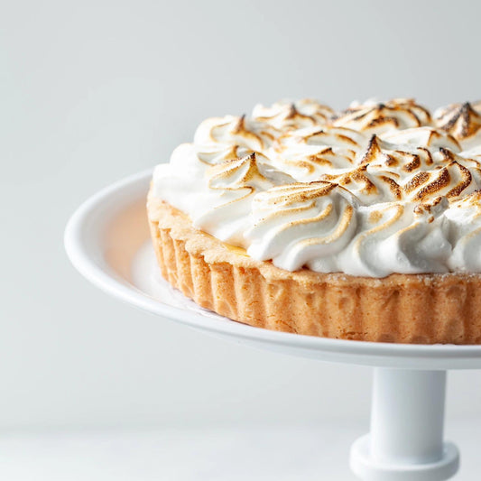 Lemon meringue pie on a white cake stand