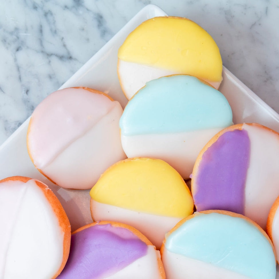 Pastel Easter Black & White cookies from William Greenberg on a triangular plate.