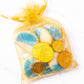 Gelt bag containing chocolate coins, blue & white cookies and dreidel.
